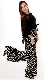 elegante ausgefallene Damenbekleidung in schwarz weiß: Modisch feminines Outfit bestehend aus einer weiten Zebra Print Hose und einer schwarzen Chiffonbluse  mit Schleifen am Ärmel, Halbarm