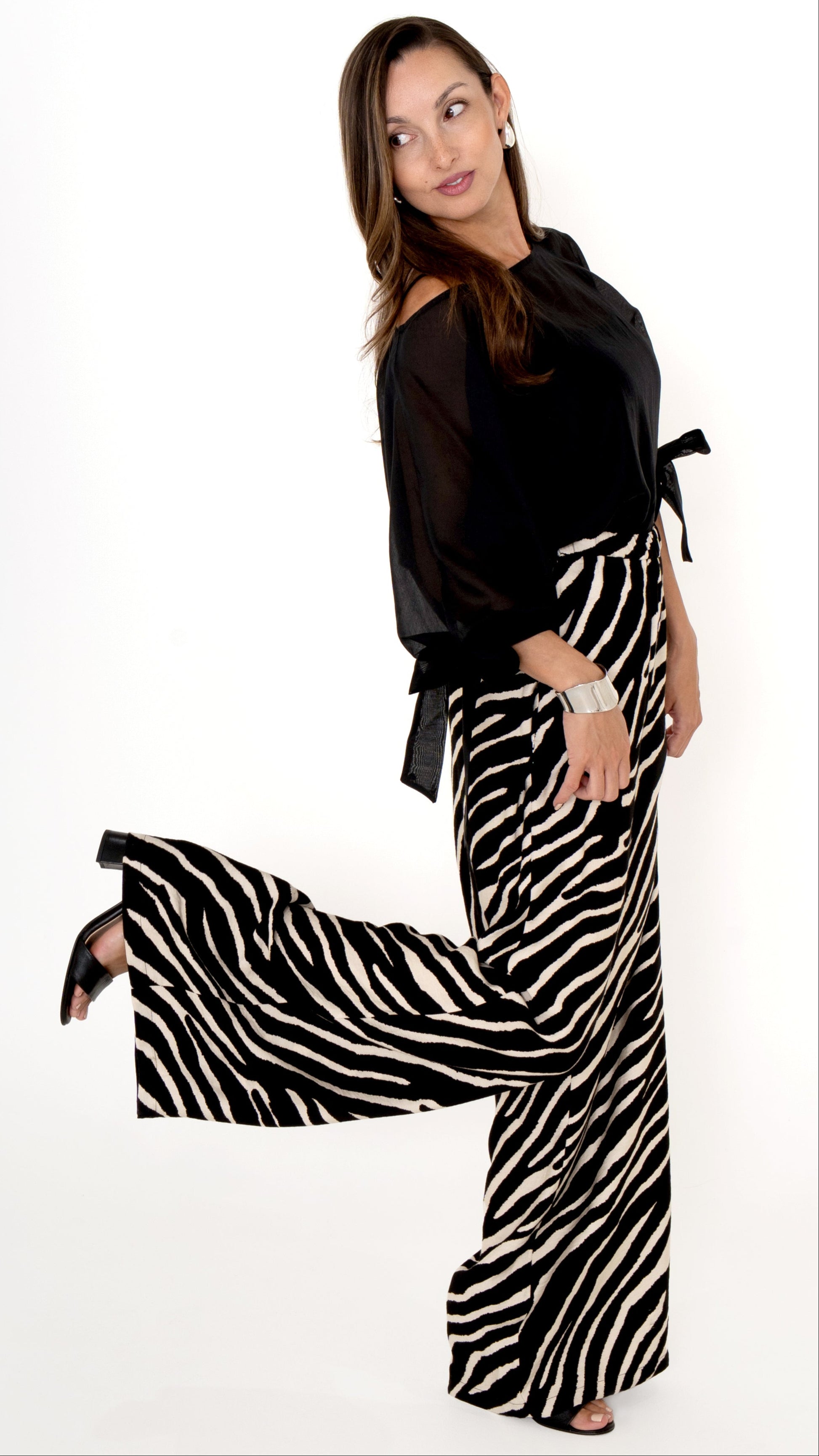 elegante ausgefallene Damenbekleidung in schwarz weiß: Modisch feminines Outfit bestehend aus einer weiten Zebra Print Hose und einer schwarzen Chiffonbluse  mit Schleifen am Ärmel, Halbarm