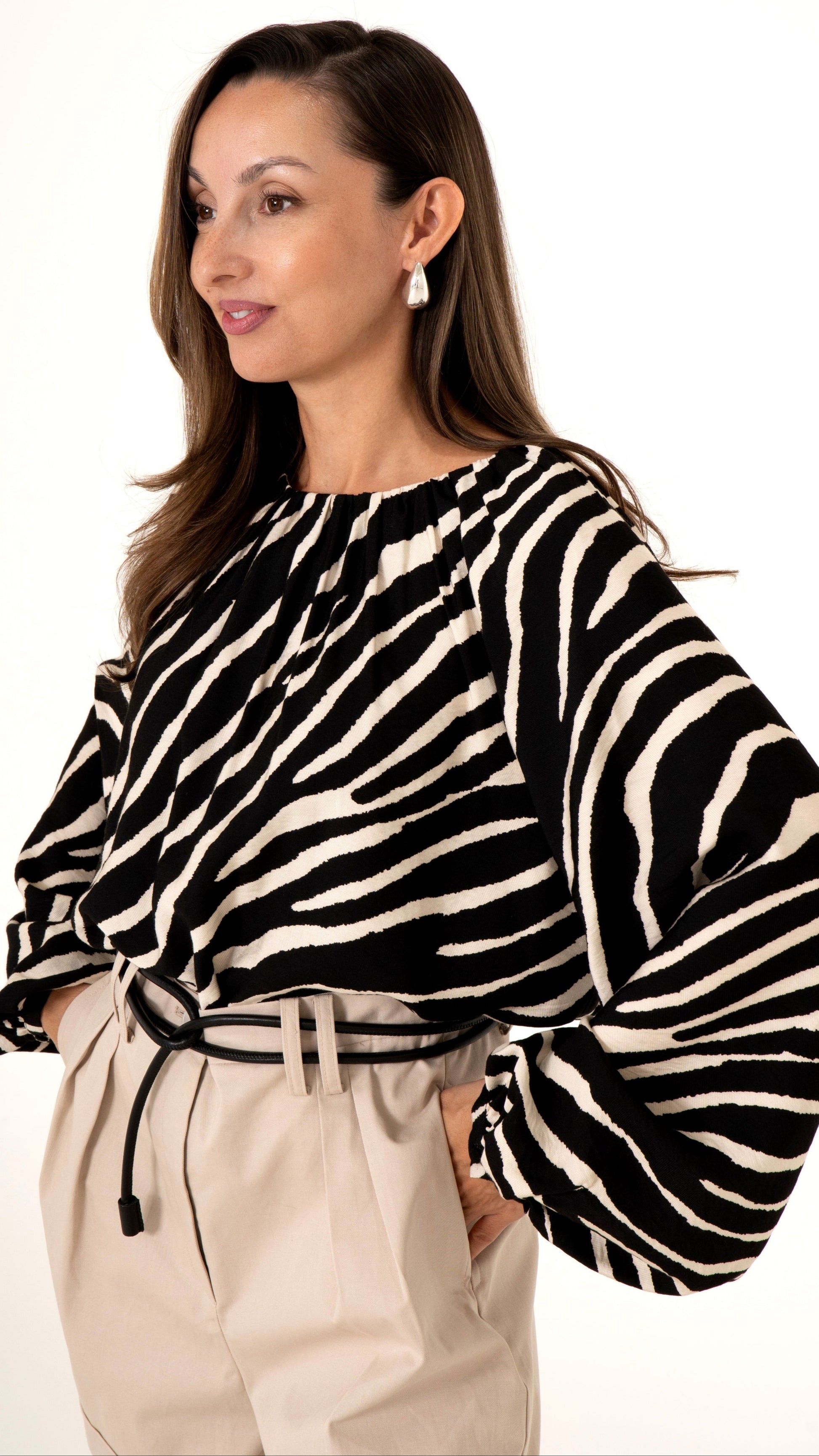 Elegante Damenmode für den Sommer: Detailansicht voluminöse Bluse in Zebra Print, kombiniert mit beiger Shorts