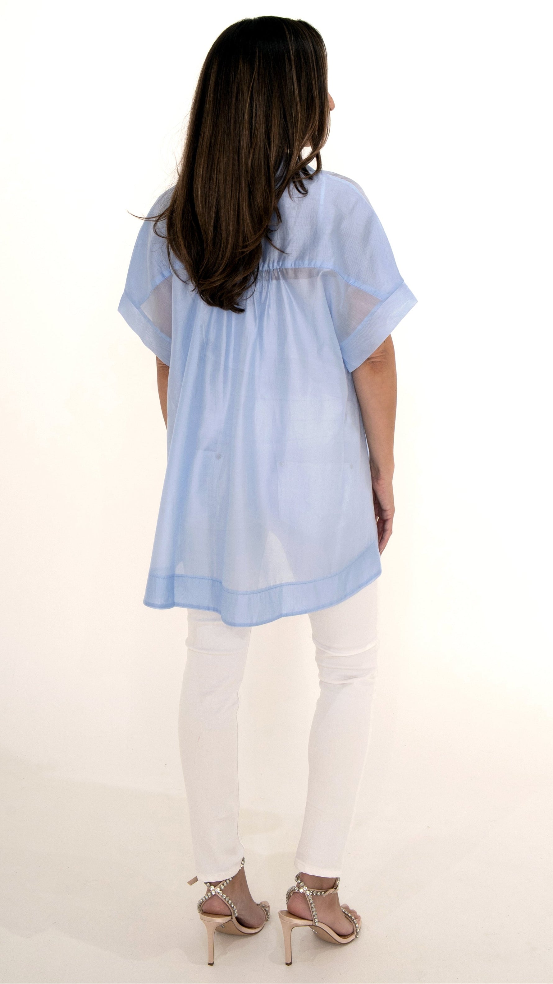 Rückansicht: Sommerliches Outfit mit Glitzer Sandalette, weiße Skinny Denim Hose und lange schwingende  hellblaue Chiffonbluse kurzarm