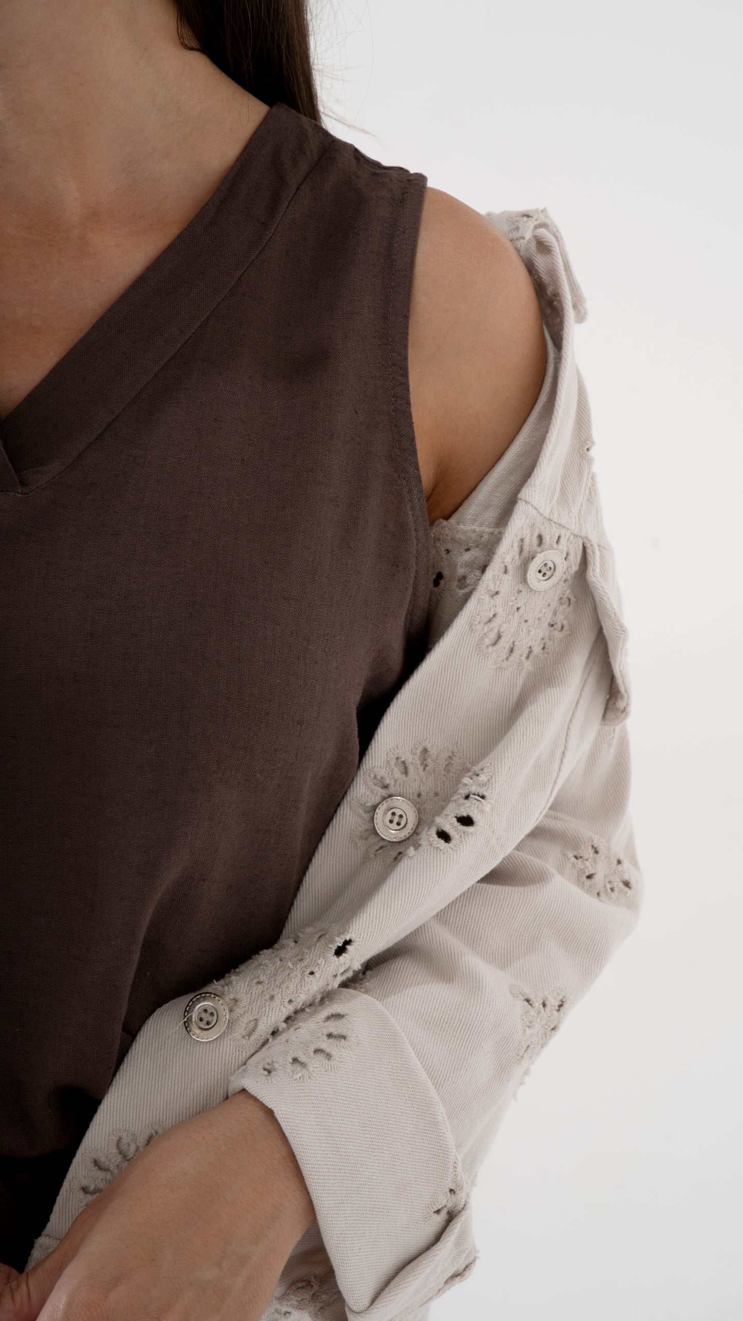 Detail Zoom Ansicht eines braunen Tops mit einer beigen Jeansjacke mit Lochstickerei