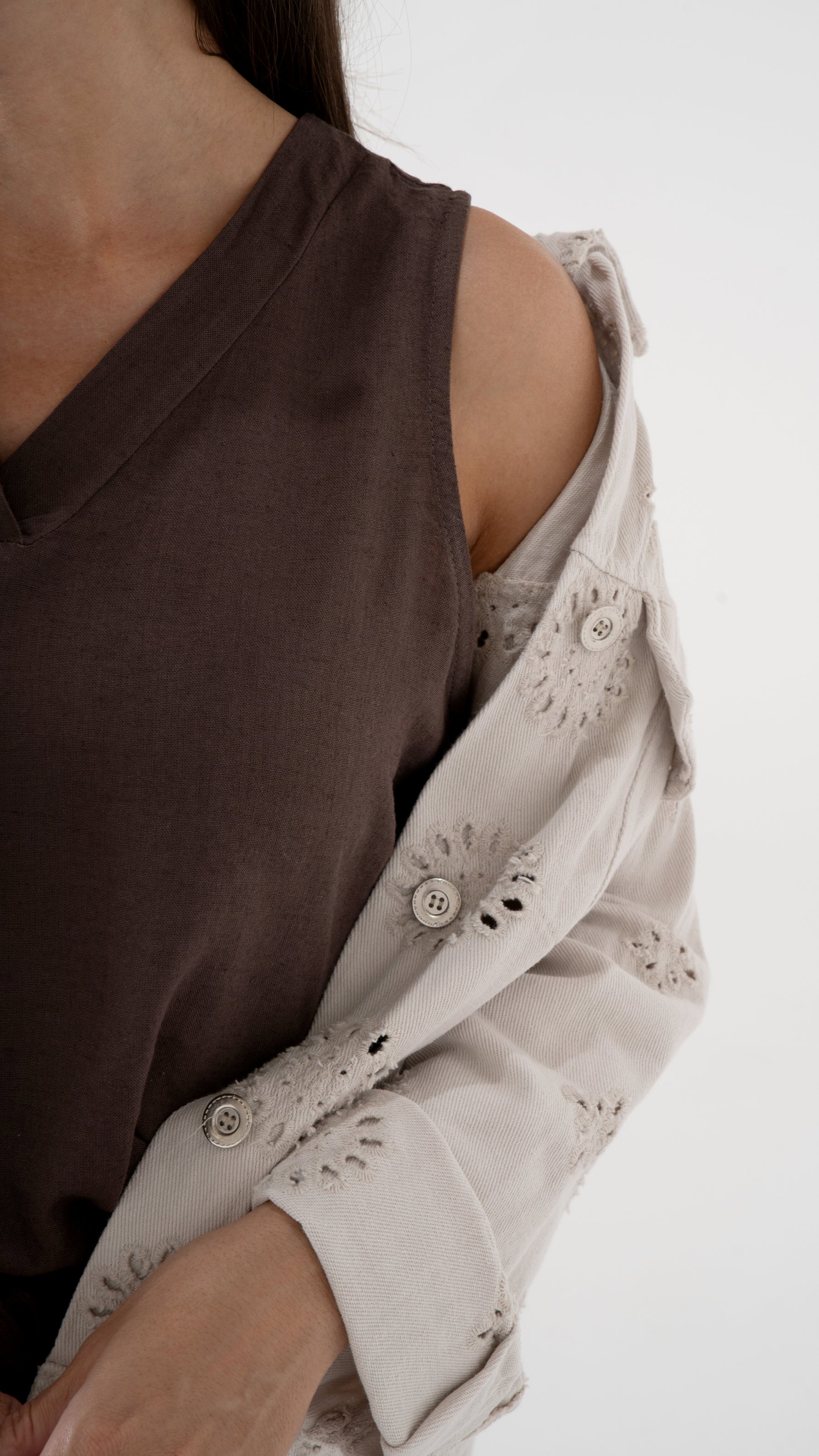 Detail Zoom Ansicht eines braunen Tops mit einer beigen Jeansjacke mit Lochstickerei