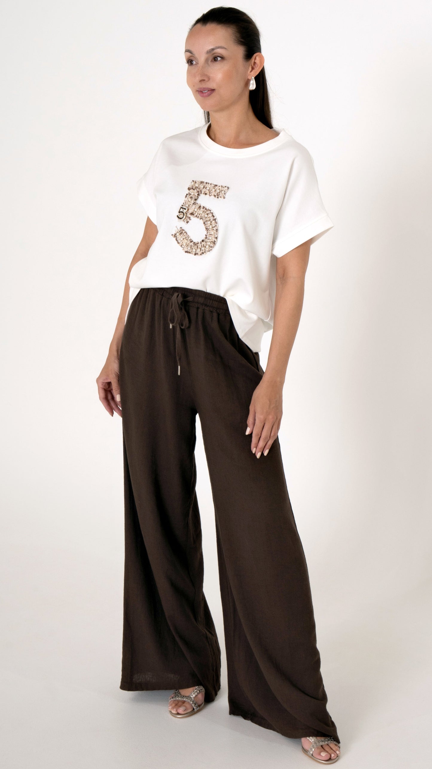 Feminine Damenbekleidung mit einem ausgefallenen Sommeroutfit: Lässig weite Leinenhose mit elastischem Bund und Bindeband. Oberteil: T-Shirt in offwite mit einer Blouclé und Perlen Stickerei mit der Zahl 5