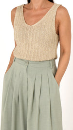 Deatilansicht goldenes Stricktop mit V Ausschnitt und weite Faltenhose in pastell grün. Sommerlich schicke Damenkleidung
