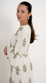 Seitenansicht Feminine Damenmode für den Sommer: Bohemian Maxikleid in offwhite mit floraler Stickerei in Pine green, Trompetenarm, Stufenkleid mit Rüschen, Gold Glitzer Metallic Details